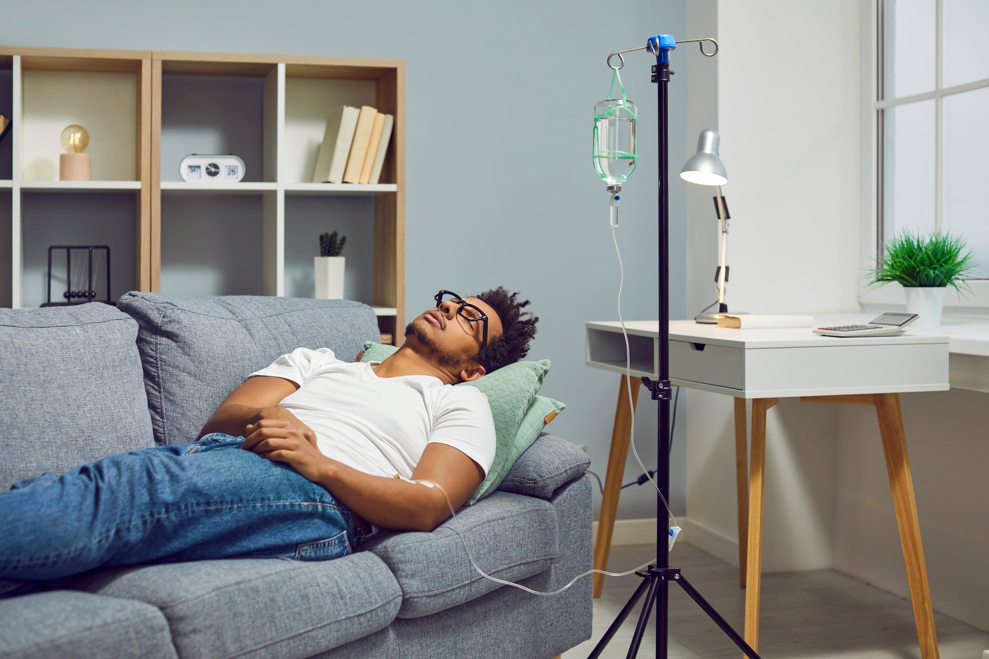 Young Man Lying on the Couch and Receiving an Intravenous Vitamin Therapy Infusion